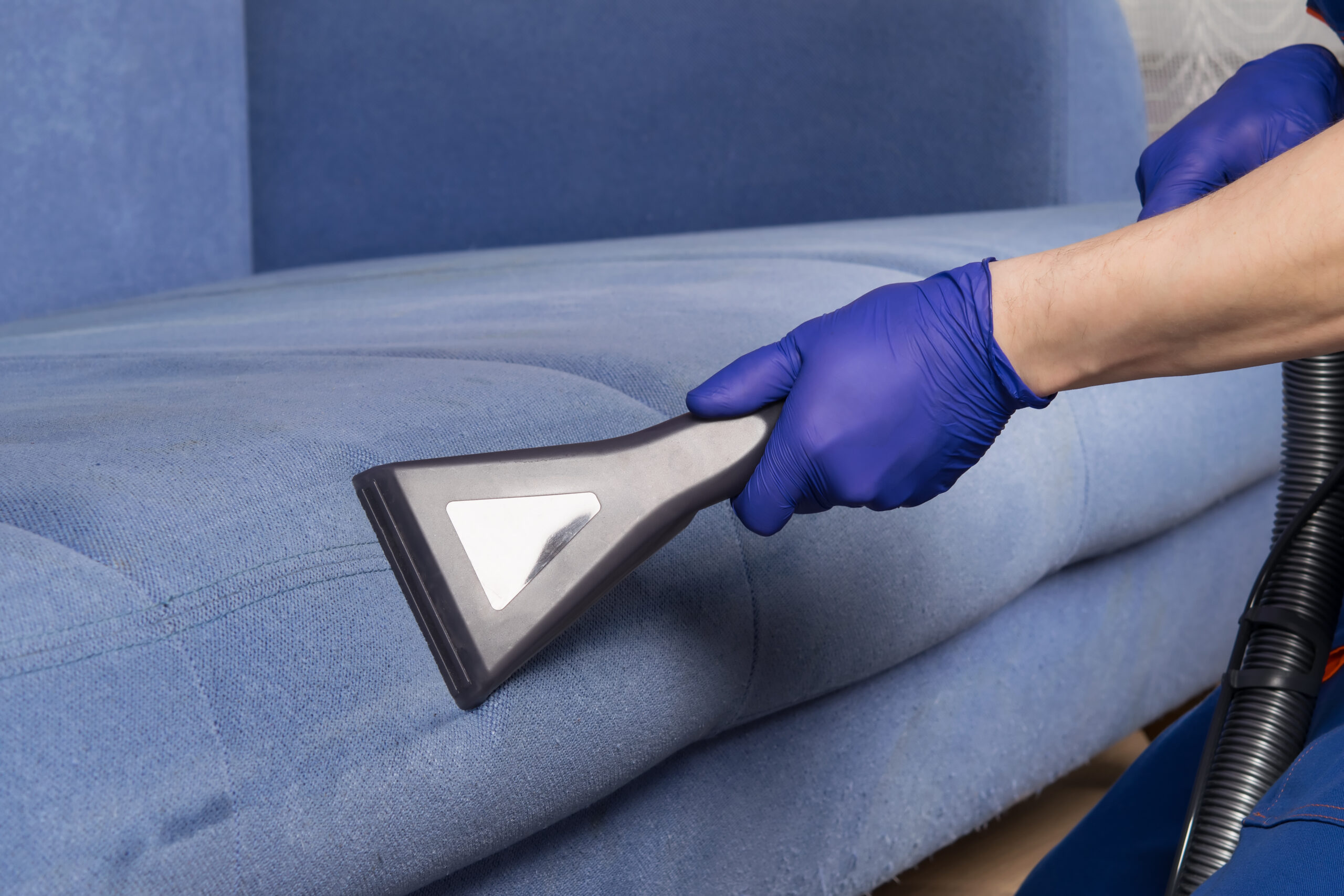 the old blue sofa is vacuumed, with a wet cleaning function to restore the perfect look, close-up