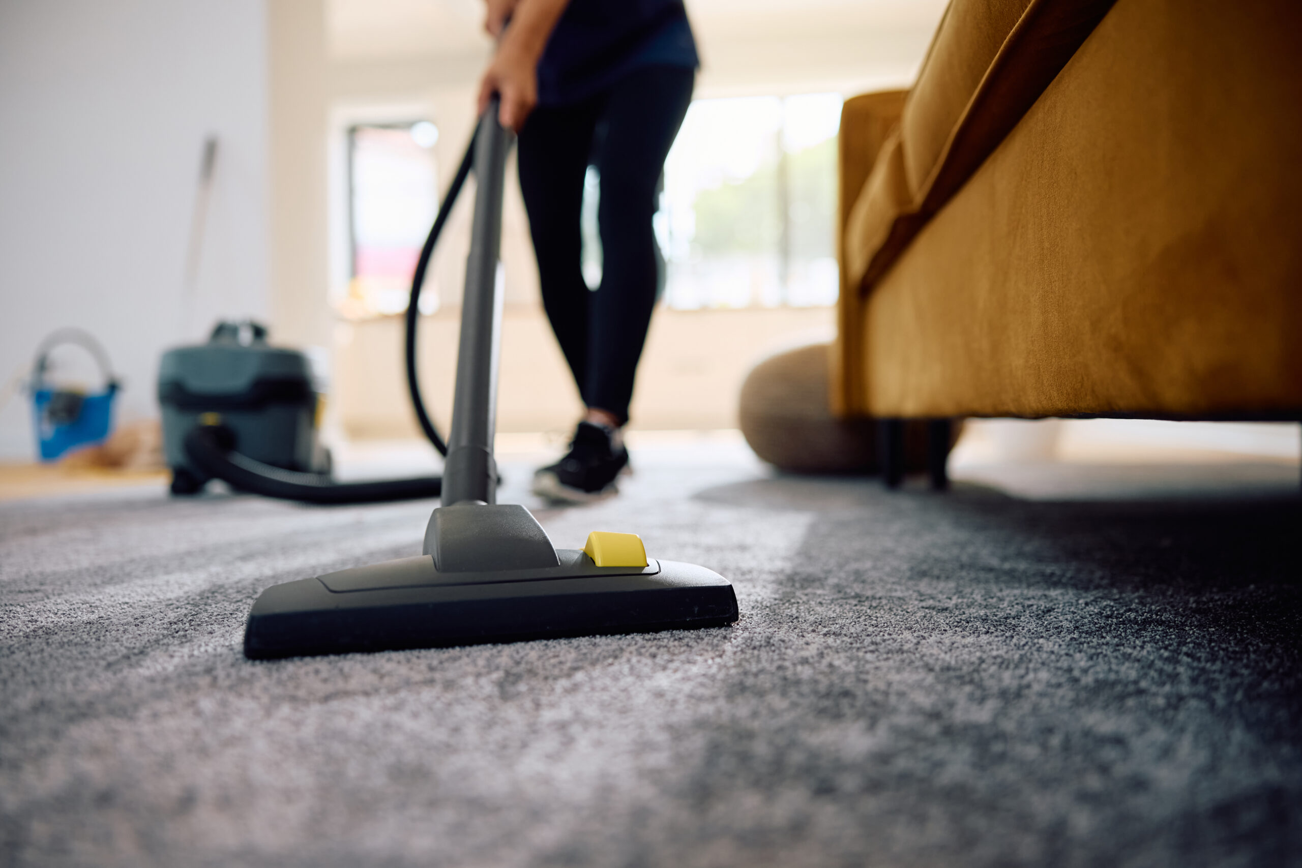Close up of woman vacuuming the carpet